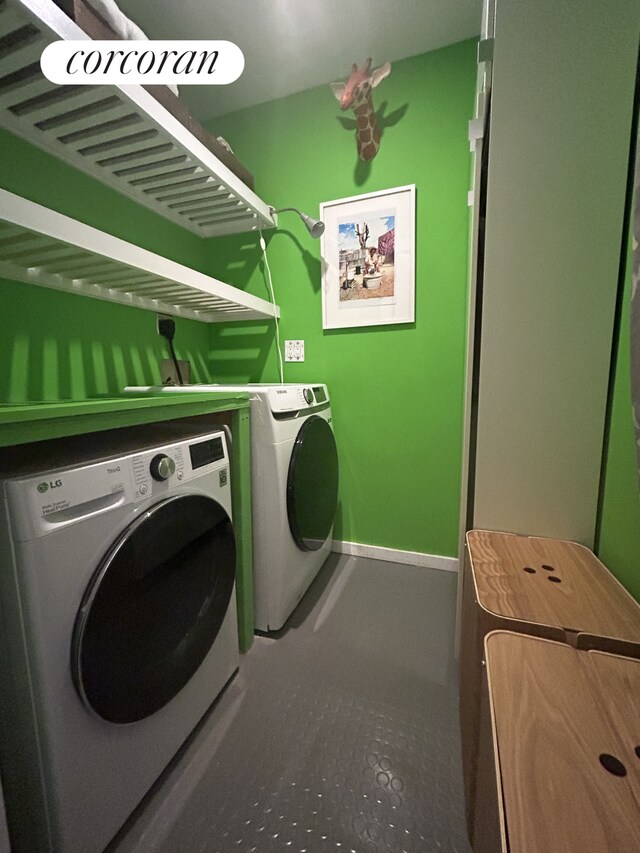 laundry room with tile patterned flooring, laundry area, baseboards, and washing machine and clothes dryer