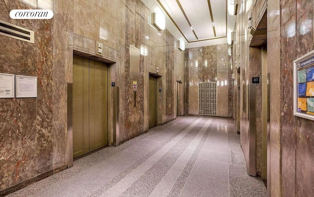 hallway featuring elevator and a high ceiling