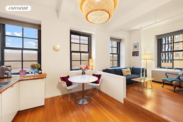 living room featuring beamed ceiling, wood finished floors, visible vents, and a chandelier