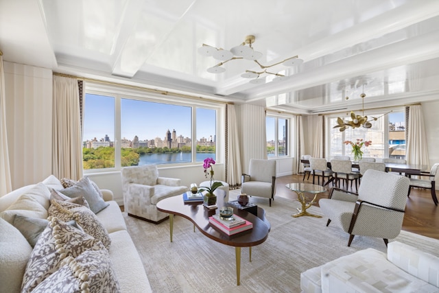 living room with a water view, beam ceiling, and a notable chandelier