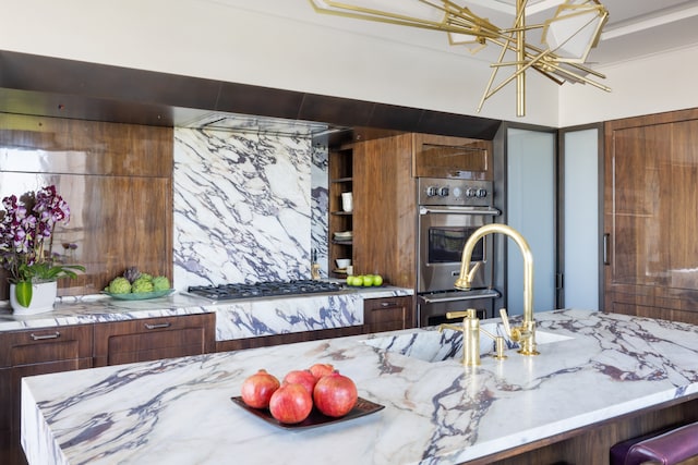 1049 5th Ave Unit 19B, New York City, NY 10028 - kitchen featuring appliances with stainless steel finishes, light stone counters, and a chandelier