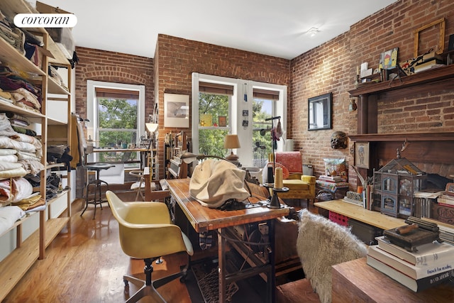interior space featuring wood finished floors and brick wall