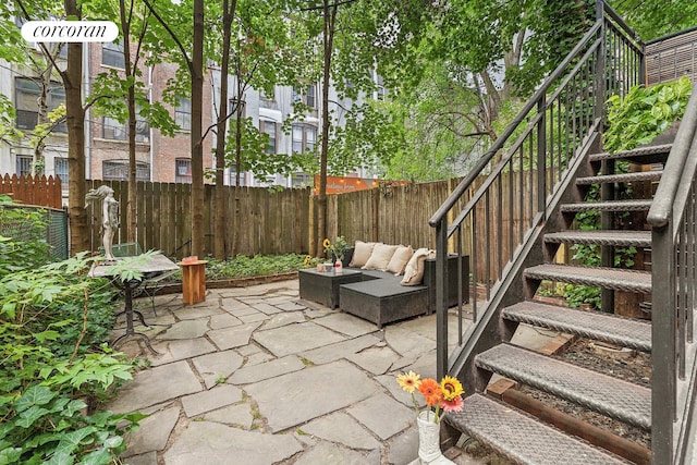 view of patio / terrace with an outdoor hangout area, stairs, a fenced backyard, and central AC unit