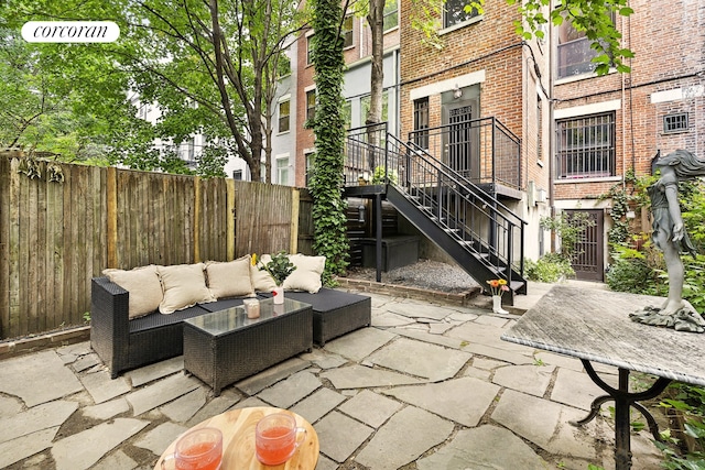 view of patio with an outdoor hangout area, stairway, and fence