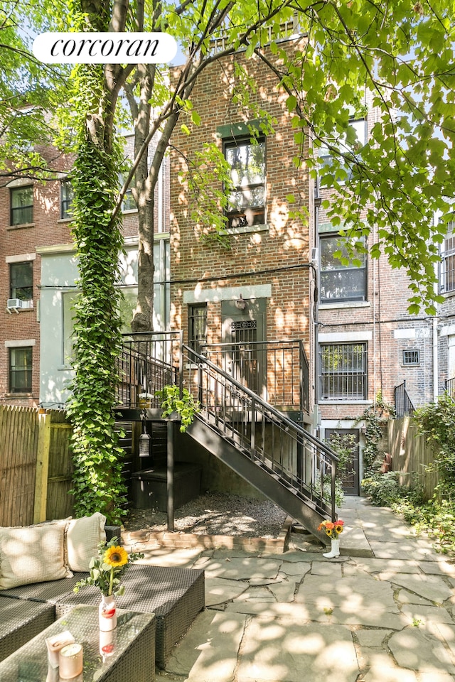 back of property with brick siding and a patio area