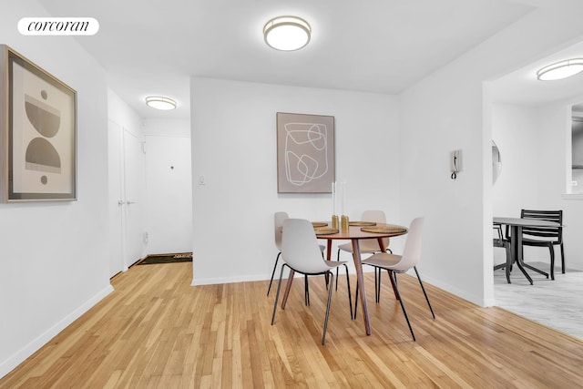 dining area featuring light wood finished floors, baseboards, and visible vents