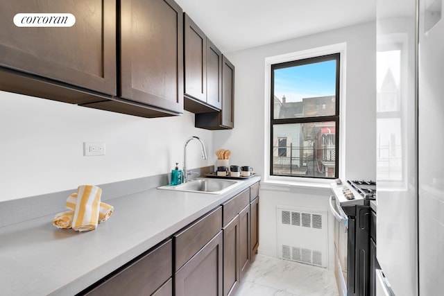 kitchen featuring a sink, dark brown cabinets, gas range oven, marble finish floor, and light countertops