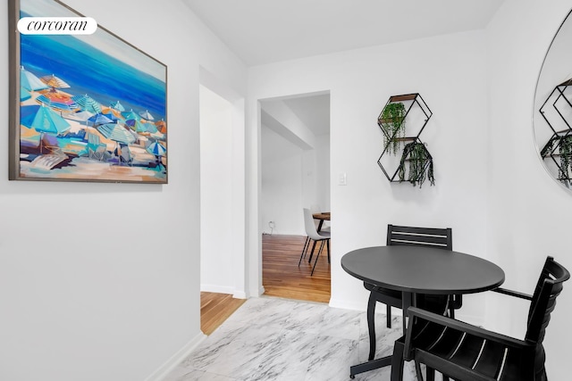 hall with marble finish floor and baseboards