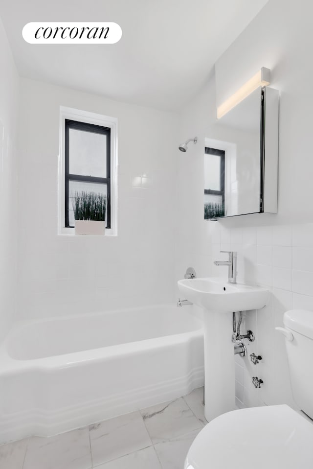 full bathroom featuring marble finish floor,  shower combination, and toilet