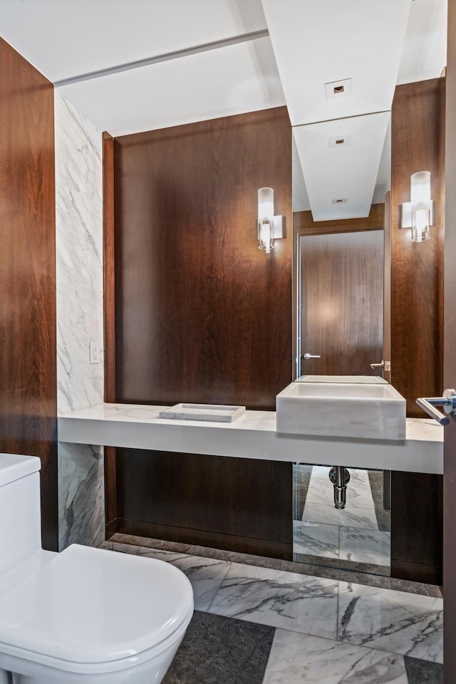 bathroom with marble finish floor and toilet