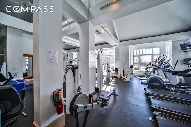 exercise room featuring visible vents and vaulted ceiling