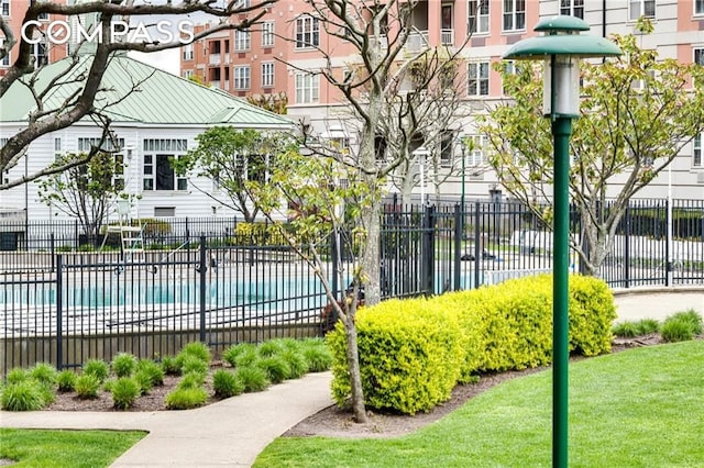 view of property's community featuring a pool and fence