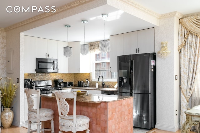 kitchen featuring stainless steel microwave, wallpapered walls, light stone countertops, a kitchen breakfast bar, and black refrigerator with ice dispenser