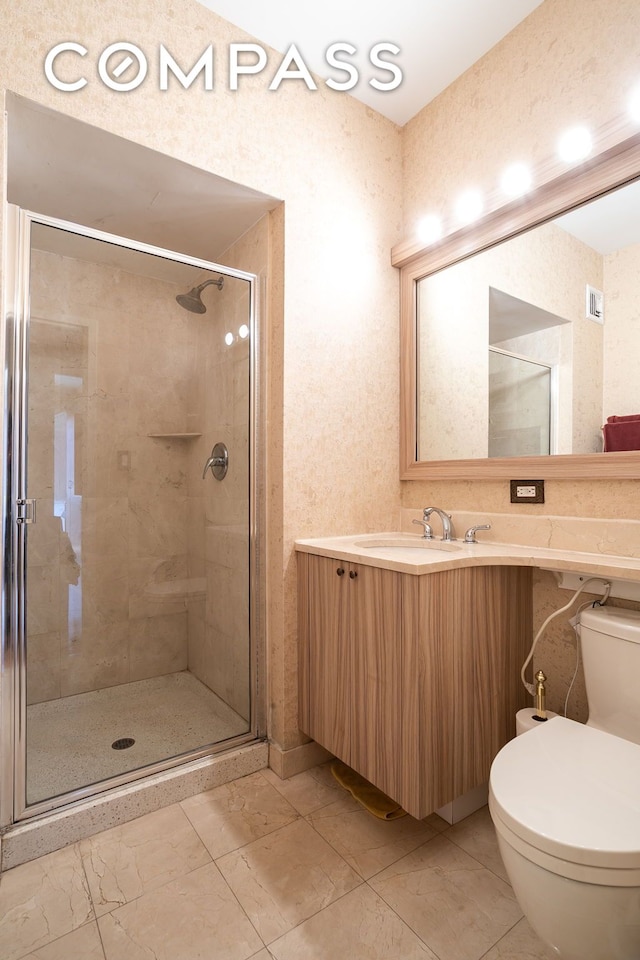 bathroom featuring toilet, marble finish floor, a stall shower, and vanity