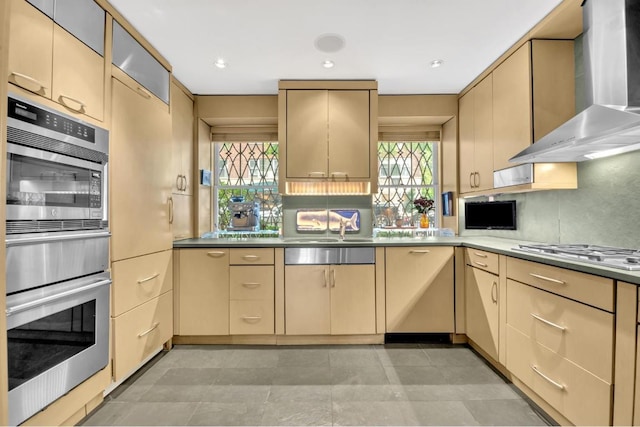 kitchen with sink, backsplash, light brown cabinetry, and wall chimney exhaust hood