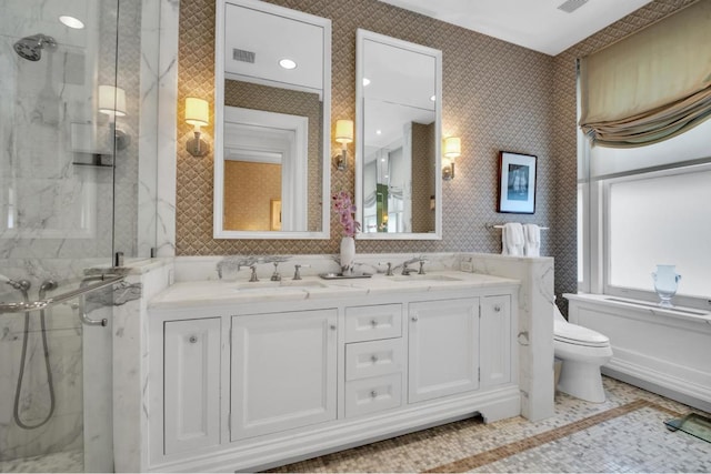 bathroom featuring vanity, a shower with shower door, and toilet