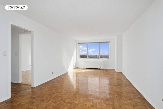 empty room featuring parquet floors and radiator