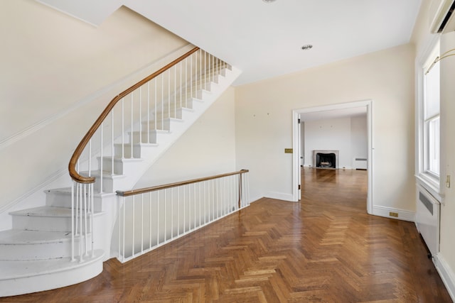 stairway featuring radiator heating unit, baseboard heating, and baseboards