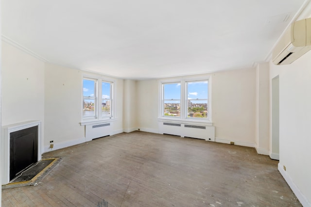 unfurnished living room featuring radiator heating unit, a wall mounted AC, and baseboards