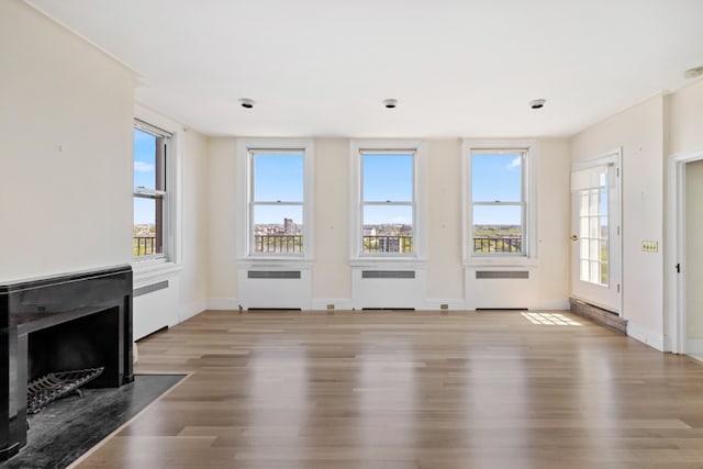 unfurnished living room featuring hardwood / wood-style flooring and radiator