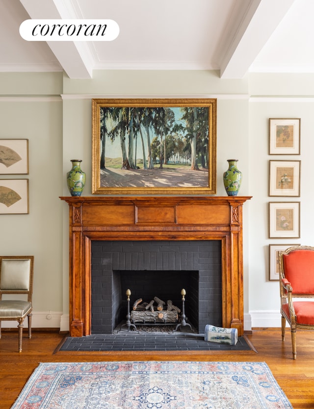 room details featuring a brick fireplace, wood finished floors, baseboards, and ornamental molding