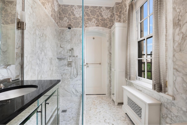 full bath featuring a marble finish shower, tile walls, and vanity