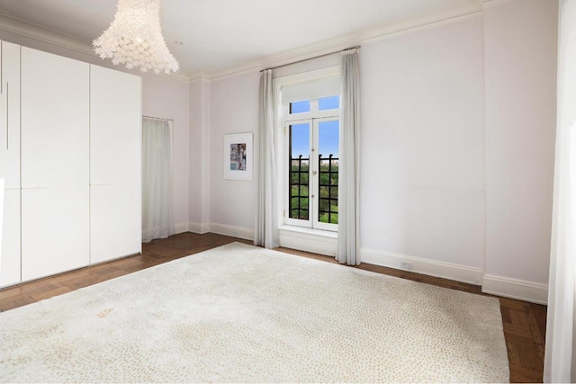 unfurnished bedroom featuring ornamental molding, parquet flooring, and a notable chandelier