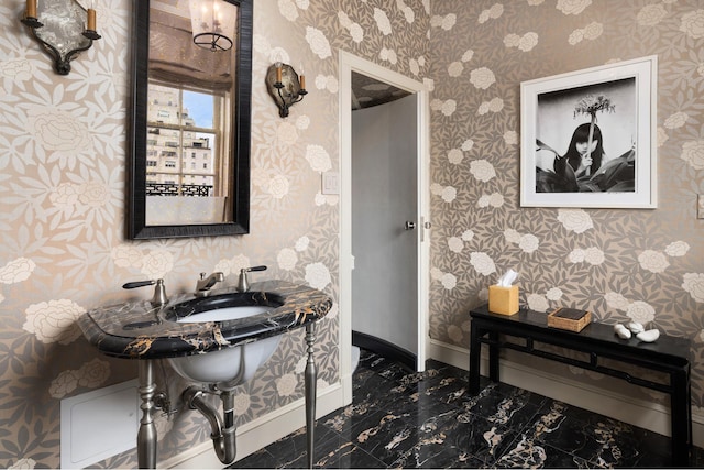 bathroom with baseboards and wallpapered walls