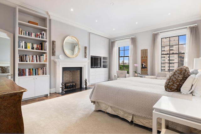 bedroom with ornamental molding, recessed lighting, a fireplace, and wood finished floors