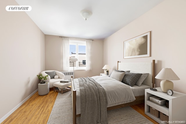 bedroom with radiator heating unit and light wood-type flooring