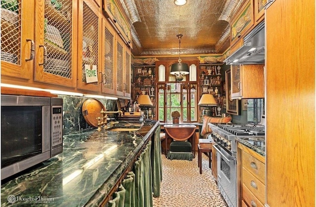 kitchen with stainless steel appliances, ornamental molding, and hanging light fixtures