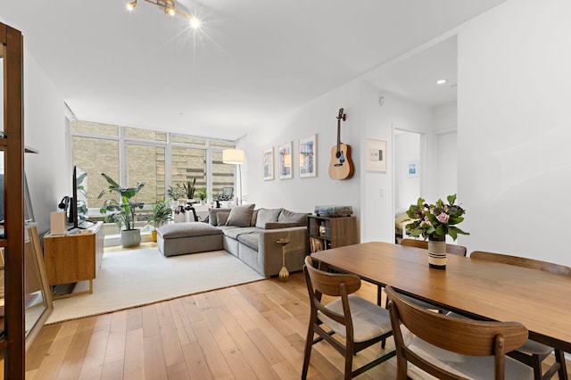 dining area featuring floor to ceiling windows and light wood-style flooring