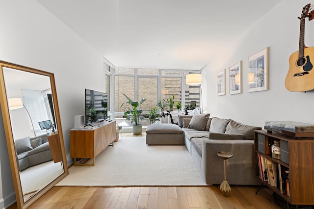 living area with wood-type flooring and a wall of windows