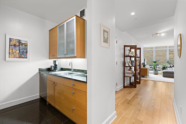 bar featuring wood finished floors, a sink, visible vents, baseboards, and dishwasher