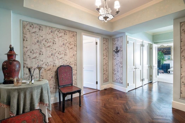 sitting room with dark parquet flooring, ornamental molding, and a chandelier