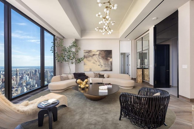 living area with an inviting chandelier and a raised ceiling