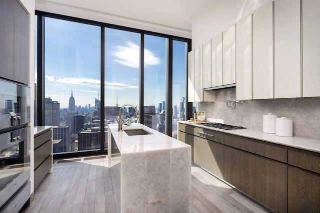 kitchen with gas stovetop, a city view, modern cabinets, and tasteful backsplash