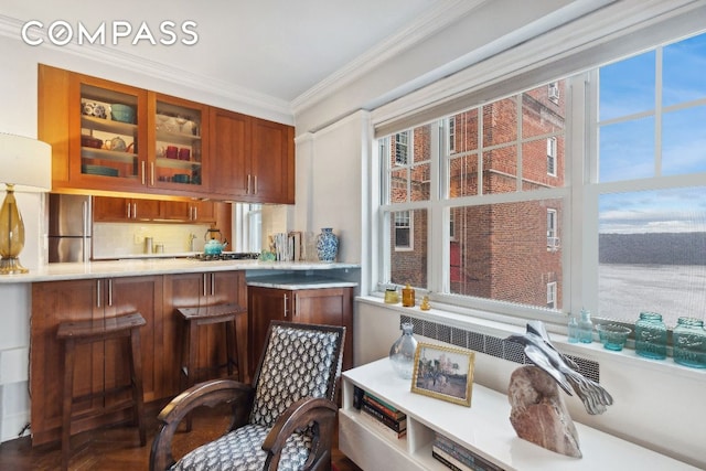 interior space with stainless steel fridge, ornamental molding, and a healthy amount of sunlight