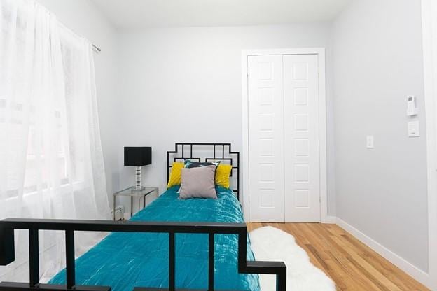 bedroom featuring a closet, baseboards, and wood finished floors