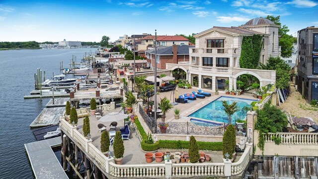 exterior space featuring a water view, a fenced in pool, and a patio