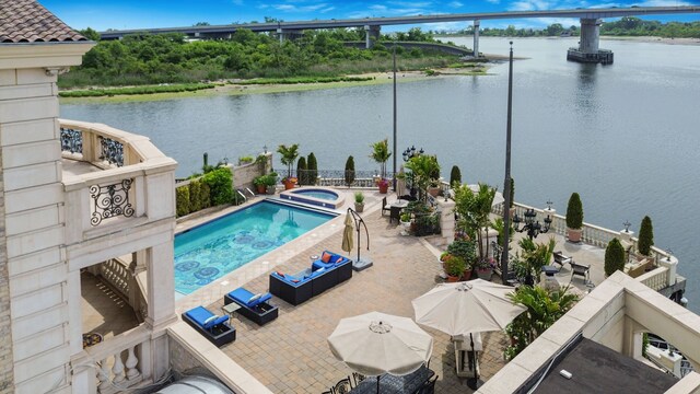 view of pool with a water view, an in ground hot tub, and a patio