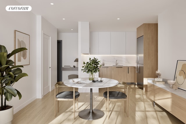 dining area featuring sink and light wood-type flooring