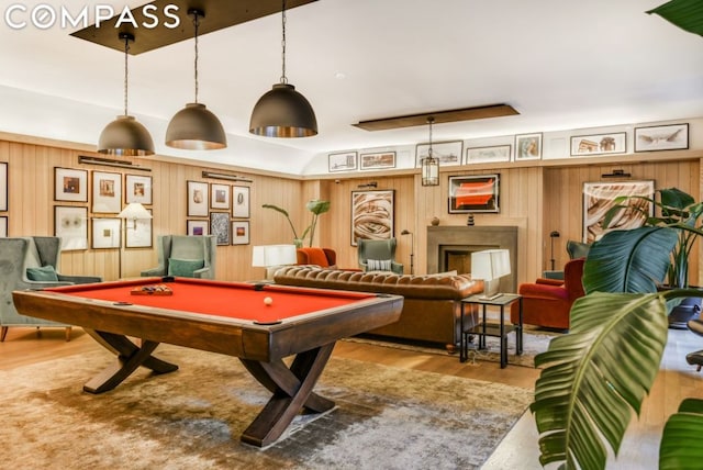 game room with billiards, light hardwood / wood-style floors, and wood walls