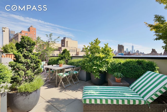 view of patio with outdoor dining area and a city view