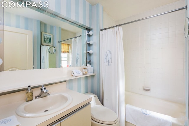 bathroom featuring shower / bath combo with shower curtain, toilet, wallpapered walls, and vanity