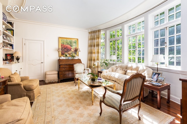 sitting room with crown molding and wood finished floors