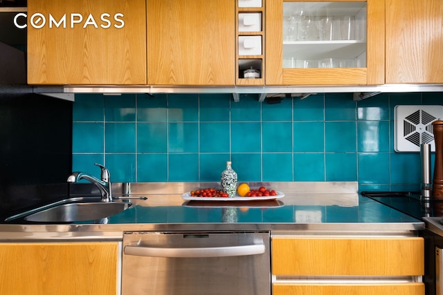 kitchen featuring stainless steel dishwasher, stainless steel countertops, backsplash, and a sink