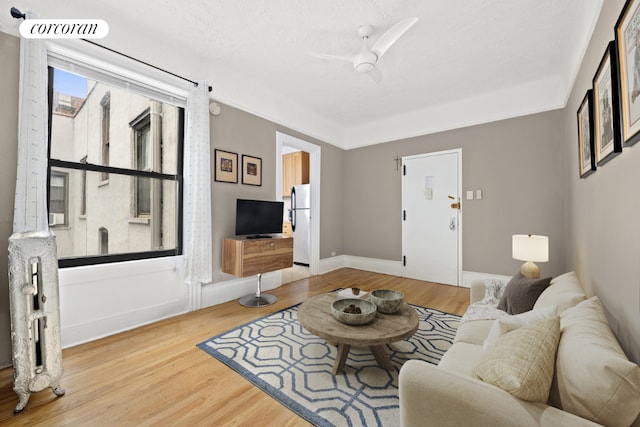 living room with hardwood / wood-style flooring, a textured ceiling, and ceiling fan