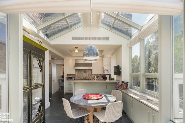 sunroom / solarium with beam ceiling and a skylight