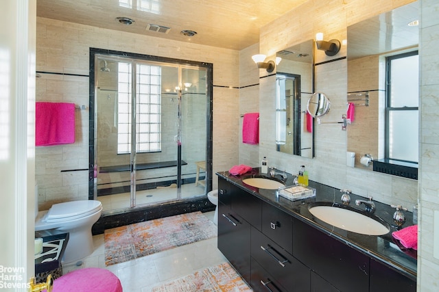 bathroom featuring walk in shower, toilet, and tile walls